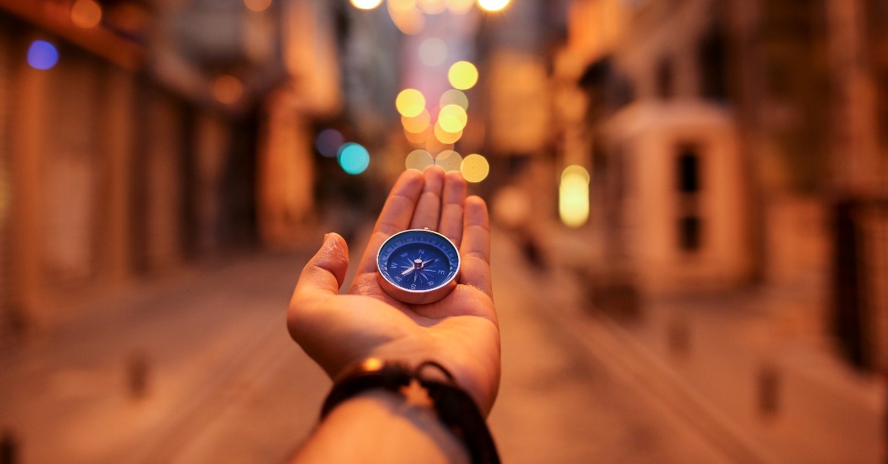 Person holding a compass in their open hand